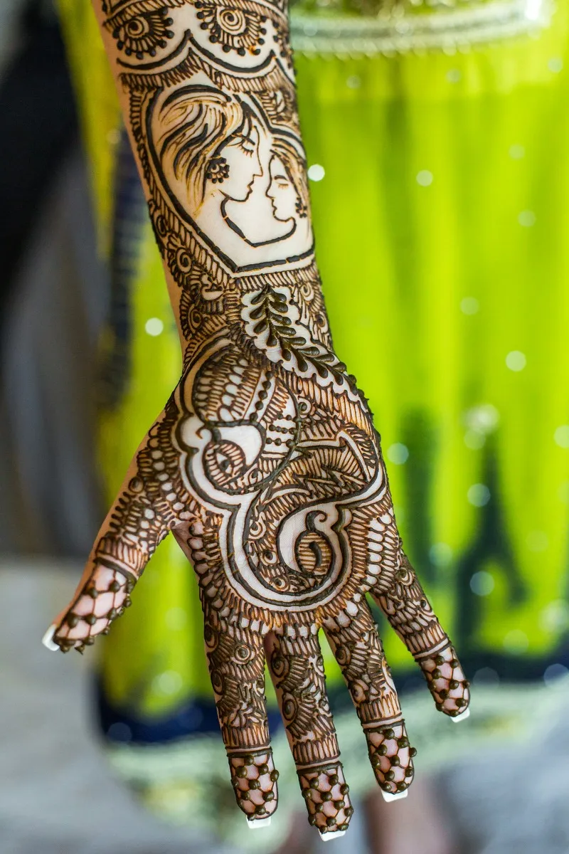 A bride's hands and forearms covered in intricate henna patterns