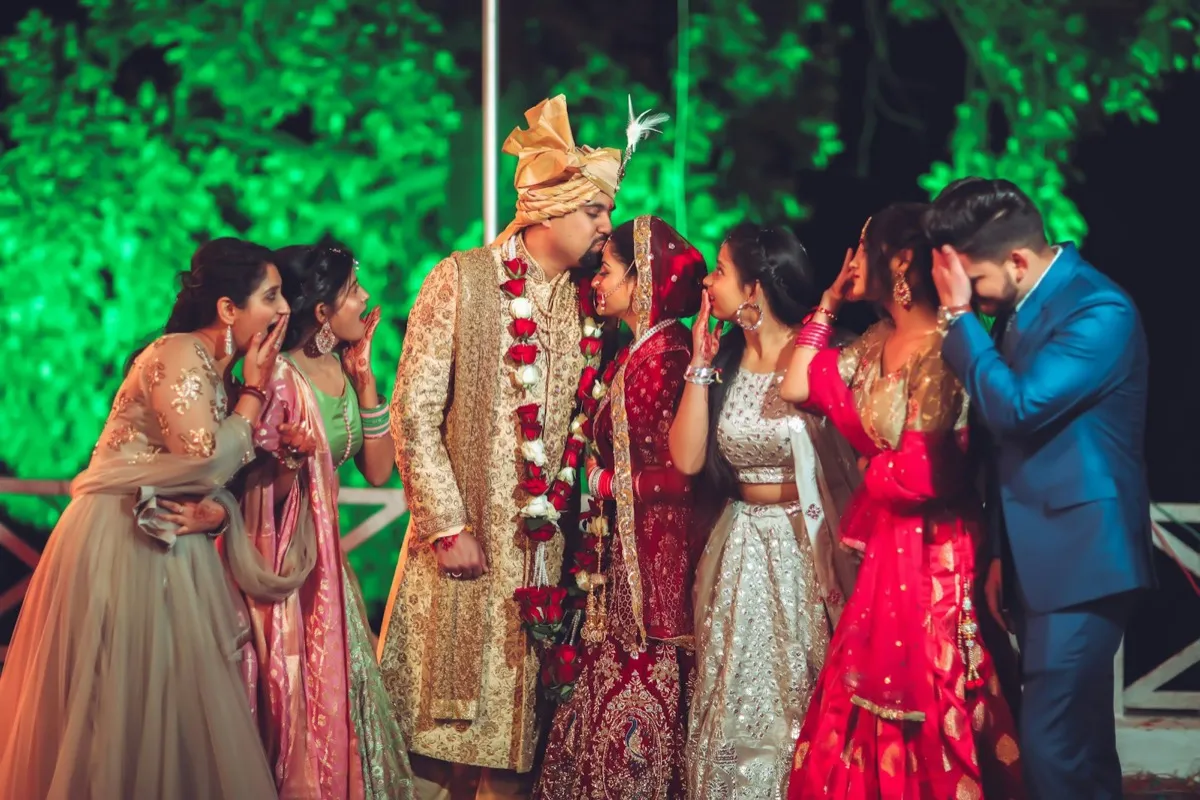 The couple surrounded by laughing friends at the reception