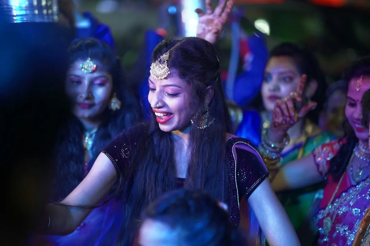 Guests dancing under lights at a sangeet night